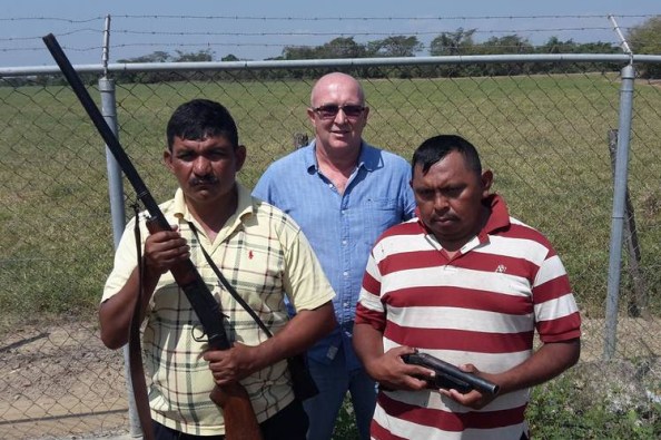 El productor arrocero Juan Martín Pérez, entre dos guardias, en su plantación en el estado Portuguesa. PHOTO: JOHN OTIS/THE WALL STREET JOURNAL