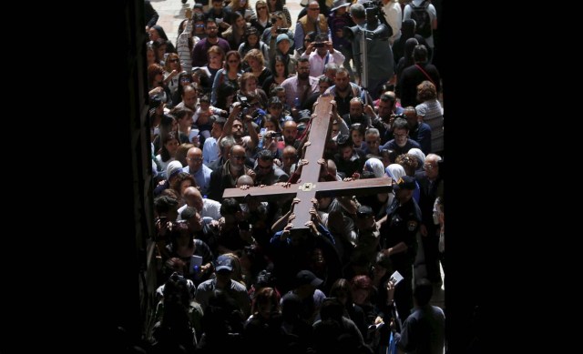 Worshippers carry a cross into the Church of the Holy Sepulcher during the Good Friday procession in Jerusalem's Old City March 25, 2016. REUTERS/Ammar Awad