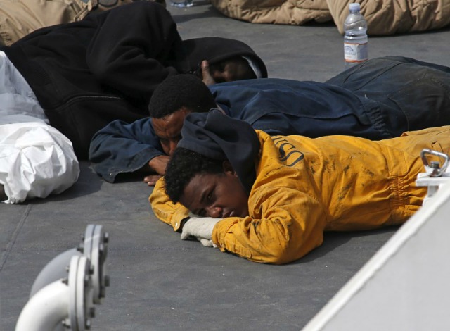 Inmigrantes sobrevivientes yacen en el piso de un navío de la guardia costera italiana, en Senglea, Malta. 20 de abril de 2015. Un estimado de 113 personas murieron en cuatro naufragios entre Libia e Italia durante el fin de semana pasado, en un cruce que es cada vez más utilizado por los inmigrantes que intentan llegar a Europa, dijo el martes la Organización Internacional para las Migraciones (OIM). REUTERS/Darrin Zammit Lupi