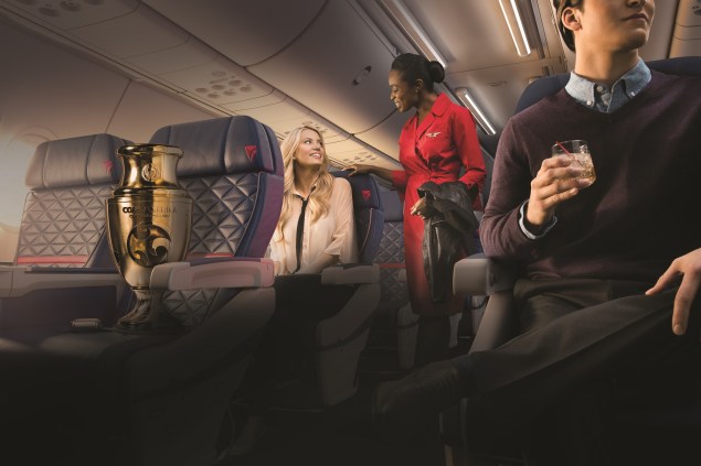 Flight Attendant chatting with customer in First Class on a Boeing 737-900ER .- These images are protected by copyright. Delta has acquired permission from the copyright owner to the use the images for specified purposes and in some cases for a limited time. If you have been authorized by Delta to do so, you may use these images to promote Delta, but only as part of Delta-approved marketing and advertising. Further distribution (including proving these images to third parties), reproduction, display, or other use is strictly prohibited.