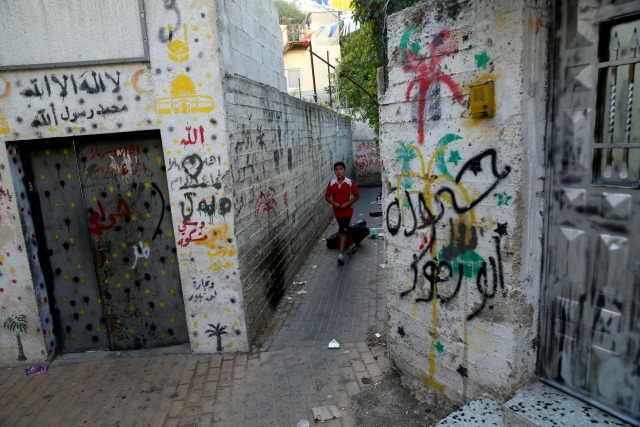 Un niño palestino camina en un callejón en Silwan, un barrio cerca palestina de la ciudad vieja de Jerusalén, 29 de junio de 2016. Foto tomada el 29 de junio de 2016. REUTERS / Ammar Awad