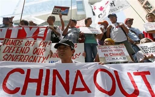 Manifestantes muestran carteles y pancartas durante una manifestación en el exterior del consulado chino antes de conocer el fallo sobre una disputa territorial con Filipinas por el mar de China Meridional, en un tribunal de La Haya. La imagen se tomó el 12 de julio de 2016, en Makati, en el este de Filipinas. (AP Foto/Bullit Marquez)