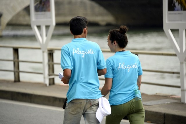 Paris Plage (Paris Beach) workers walk on the bank of the Seine river, in central Paris, on July 20, 2016 on the opening day of the event. The 15th edition of Paris Plage will run until September 4, 2016. / AFP PHOTO / BERTRAND GUAY