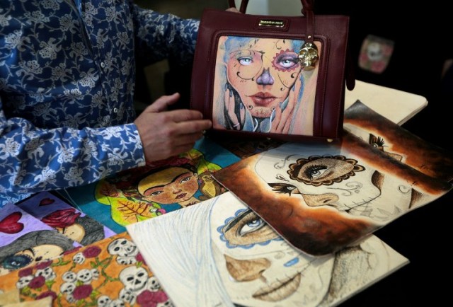 El presidente de la Fundación de Arte prisión, Jorge Cueto, muestra una bolsa durante una entrevista con la AFP en una tienda de la marca en el exclusivo barrio de Polanco, Ciudad de México, el 14 de junio de 2016. AFP PHOTO / Pedro Pardo