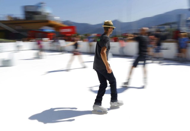 Rio Olympics - Lagoa - Rio de Janeiro, Brazil - 01/08/2016. People use adapted ice skates to skate on an artificial ice rink at the Switzerland house. REUTERS/Ivan Alvarado FOR EDITORIAL USE ONLY. NOT FOR SALE FOR MARKETING OR ADVERTISING CAMPAIGNS.