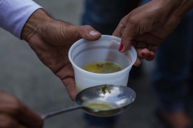 CAR06. CARACAS (VENEZUELA), 10/09/2016.- Un grupo de personas preparan un sancocho hoy, sábado 10 de septiembre del 2016, en la ciudad de Caracas (Venezuela). En el barrio la Unión, ubicado en la favela más grande de América Latina asentada en el este de Caracas, se preparó hoy un gran "sancocho" como se le conoce en Venezuela a la sopa cocinada con varios tipos de verduras y carnes, para alimentar a los vecinos, muchos de ellos con varios días de hambre. EFE/MIGUEL GUTIÉRREZ