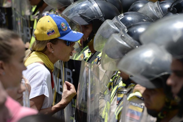 Venezuelan opposition aleader lilian Tintori argues with police during a march in Caracas on September 16, 2016 demanding to the government to set the date for a recall referendum against President Nicolas Maduro. The Venezuelan opposition's push for a vote to remove President Maduro ran into a roadblock Thursday when authorities announced a delay in setting the date for the final stage in the process.  / AFP PHOTO / FEDERICO PARRA