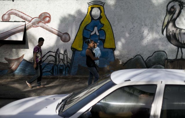 En esta imagen, tomada el 13 de septiembre de 2016, un mural de la Virgen del Valle, patrona de la isla de Margarita, decora un muro en la localidad insular de Porlamar, en Venezuela. Este pueblo turístico solía estar lleno de turistas extranjeros atraídos por sus aguas cristalinas, playas de arena fina y el buen tiempo. Ahora, las piscinas están vacías, los sanitarios no funcionan y muchos hoteles no pueden permitirse ofrecer servicio de comidas. (AP Foto/Ariana Cubillos)