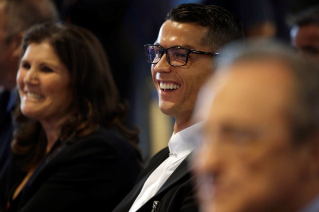 Real Madrid's Cristiano Ronaldo (C) smiles next to his mother Dolores Aveiro and the club's president Florentino Perez during a ceremony for Ronaldo's contract renewal at Santiago Bernabeu stadium in Madrid, Spain, November 7, 2016.  REUTERS/Susana Vera