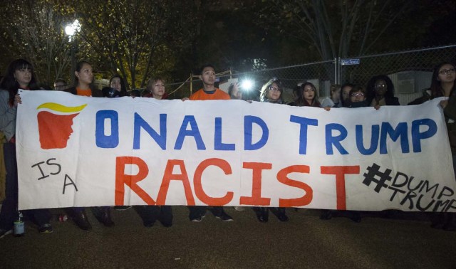 MHR33 WASHINGTON (EE.UU.), 09/11/2016.- Unos inmigrantes sostienen una pancarta en la que se lee "Donald Trump es un racista" entre un grupo de personas reunidas frente a la Casa Blanca en Washington DC, Estados Unidos, hoy, 9 de noviembre de 2016. El candidato republicano, Donald Trump, ha ganado hoy las elecciones presidenciales en Estados Unidos y tomará posesión se su cargo en enero. EFE/Michael Reynolds