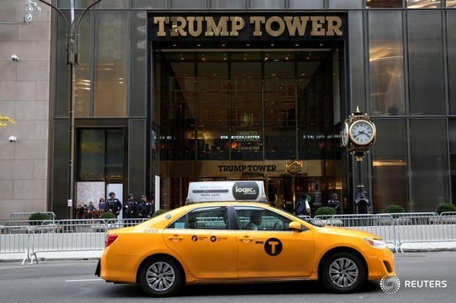 En la imagen, un taxi de la ciudad de Nueva York pasa frente a la Torre Trump, Estados Unidos, 10 de noviembre, 2016. Bailey White, de 13 años, se paró pacientemente el miércoles por la tarde con su pequeño hermano Keaton en una fila de la tienda de regalos ubicada dentro de la Torre Trump en la Quinta Avenida de Nueva York, cada uno con un terrier de peluche llamado Charlie que costaba 35 dólares.  REUTERS/Brendan McDermid - RTX2T3QA