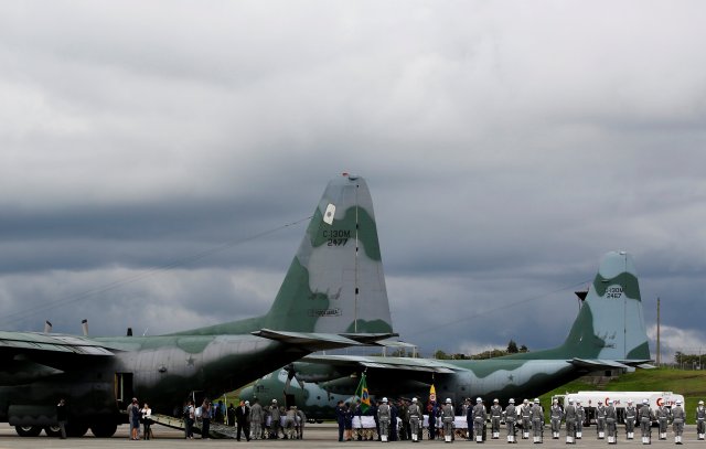 Military personnel unload a coffin with the remains of Brazilian victims who died in an accident of the plane that crashed into the Colombian jungle with Brazilian soccer team Chapecoense, at the airport from where the bodies will be flown home to Brazil, in Medellin, Colombia December 2, 2016. REUTERS/Jaime Saldarriaga