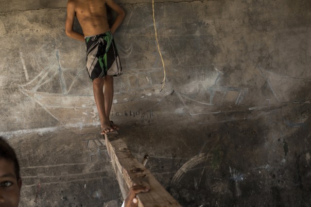 En esta imagen, tomada el 30 de octubre de 2016, niños juegan en el interior de un almacén utilizado por pescadores para guardar sus redes y reparar los barcos en Punta de Araya, en el estado de Sucre, Venezuela. Desesperados, los venezolanos se roban lo que queda de tiempos mejores: se llevan las redes de las lanchas de pesca, los generadores de electricidad y los motores fuera de borda. El cálido mar Caribe se está convirtiendo en un sitio donde la gente vela exclusivamente por sus propios intereses y todo vale. (AP Foto/Rodrigo Abd)