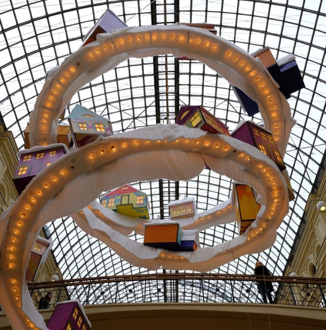 Customers are seen on a bridge as they walk past Christmas decorations in the GUM Department Store in Moscow on December 9, 2016. / AFP PHOTO / Yuri KADOBNOV