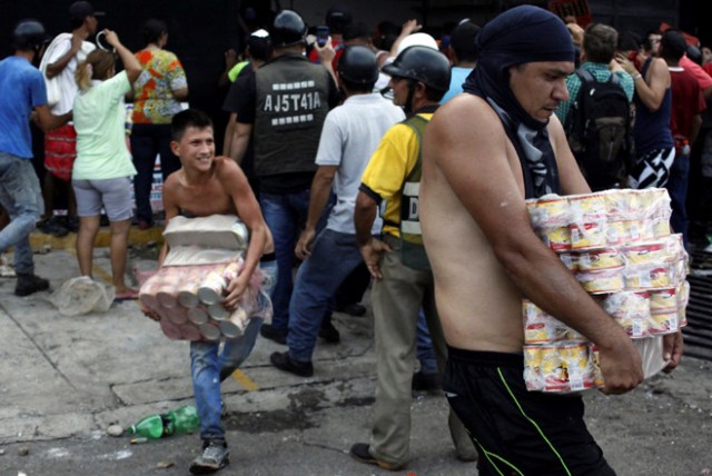 People carry goods taken from a food wholesaler after it was broken into, in La Fria, Venezuela December 17, 2016. REUTERS/Carlos Eduardo Ramirez