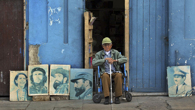 Un anciano con cuadros de dirigentes revolucionarios en La Habana. (EFE)