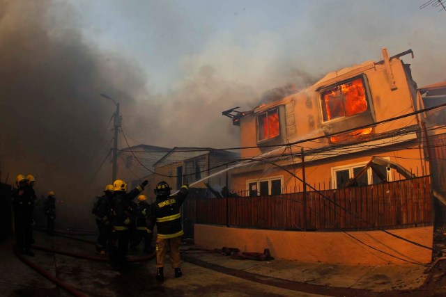 CH01. VALPARAISO (CHILE), 02/01/2017.- Personal de bomberos combate un incendio forestal en el sector de Playa Ancha en la ciudad de Valparaíso (Chile) hoy, 2 de enero de 2016, que afectó a viviendas y vecinos del sector. Un incendio forestal que estalló hoy en la parte alta del puerto chileno de Valparaíso llevó a las autoridades a declarar alerta roja en la ciudad y a disponer la evacuación preventiva de unas 25 viviendas próximas al foco de fuego, informaron fuentes oficiales. EFE/SEBASTIAN CISTERNAS