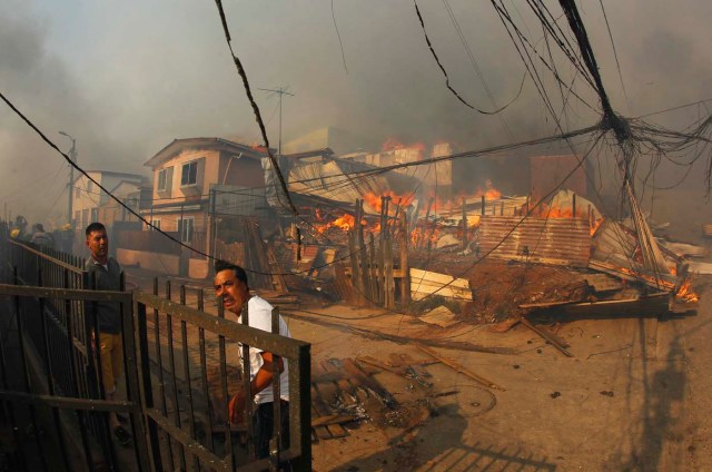 CH01. VALPARAISO (CHILE), 02/01/2017.- Vecinos ayudan a combatir un incendio forestal en el sector de Playa Ancha en la ciudad de Valparaíso (Chile) hoy, 2 de enero de 2016, que afectó a viviendas y vecinos del sector. Un incendio forestal que estalló hoy en la parte alta del puerto chileno de Valparaíso llevó a las autoridades a declarar alerta roja en la ciudad y a disponer la evacuación preventiva de unas 25 viviendas próximas al foco de fuego, informaron fuentes oficiales. EFE/SEBASTIAN CISTERNAS