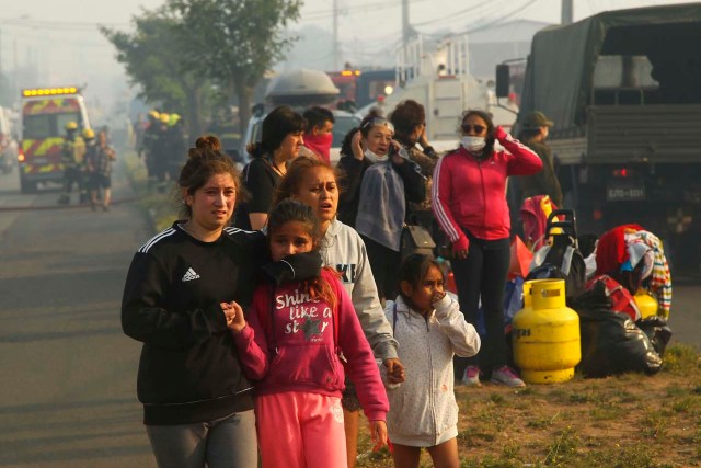 CH01. VALPARAISO (CHILE), 02/01/2017.- Un grupo de personas afectada por un incendio forestal en el sector de Playa Ancha en la ciudad de Valparaíso (Chile) hoy, 2 de enero de 2016, que afectó a viviendas y vecinos del sector. Un incendio forestal que estalló hoy en la parte alta del puerto chileno de Valparaíso llevó a las autoridades a declarar alerta roja en la ciudad y a disponer la evacuación preventiva de unas 25 viviendas próximas al foco de fuego, informaron fuentes oficiales. EFE/SEBASTIAN CISTERNAS