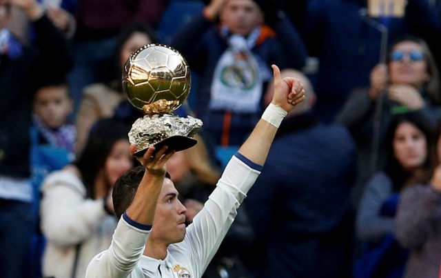 Football Soccer - Real Madrid v Granada - Spanish La Liga Santander - Santiago Bernabeu stadium, Madrid, Spain - 7/1/17 - Real Madrid's Cristiano Ronaldo holds his Ballon d'Or (Golden Ball) trophy to the crowd after winning the FIFA World Player of the Year 2016 award, before their Spanish first division soccer match against Granada. REUTERS/Juan Medina TPX IMAGES OF THE DAY