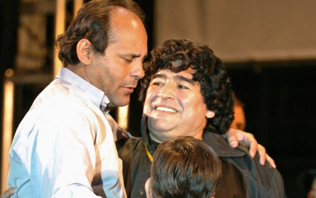 BAS15. BUENOS AIRES (ARGENTINA), 09/01/2017.- Fotografía de archivo del 4 de abril de 2005 del exfutbolista paraguayo Roberto Cabañas (i) junto a su hijo (c) abrazando a Diego Armando Maradona (d) en la celebración del centenario del club Boca Juniors anoche en el estadio "La Bombonera" de Buenos Aires. Cabañas, quien fue delantero del argentino Boca Juniors e integró la selección de Paraguay que ganó la Copa América en 1979, falleció hoy, lunes 9 de enero de 2017, a consecuencia de una parada cardio-respiratoria, según informaron sus familiares a los medios locales. EFE/Cézaro De Luca