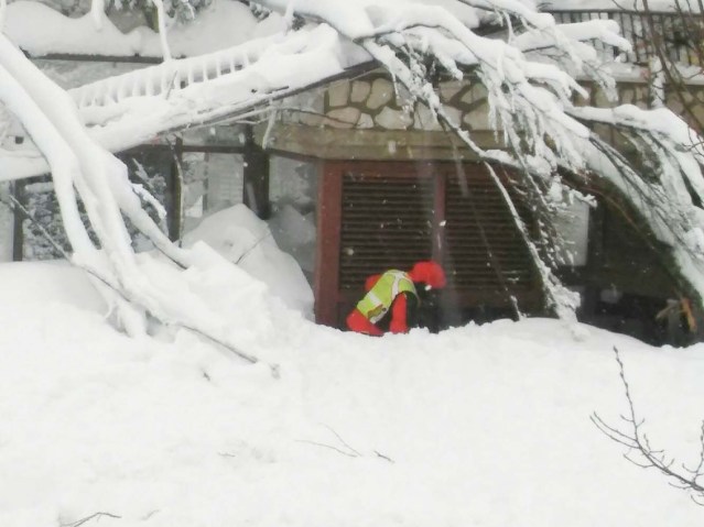 A member of Lazio's Alpine and Speleological Rescue Team is seen in front of the Hotel Rigopiano in Farindola, central Italy, hit by an avalanche, in this January 19, 2017 handout picture provided by Lazio's Alpine and Speleological Rescue Team. Soccorso Alpino Speleologico Lazio/Handout via REUTERS  ATTENTION EDITORS - THIS IMAGE WAS PROVIDED BY A THIRD PARTY. EDITORIAL USE ONLY. NO RESALES. NO ARCHIVE.