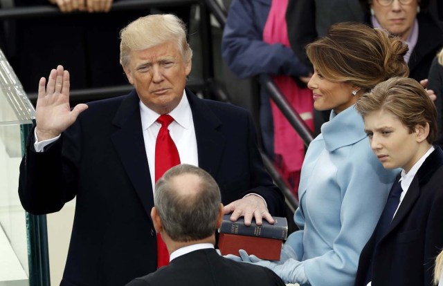 US President Donald Trump takes the oath of office with his wife Melania and son Barron at his side, during his inauguration at the U.S. Capitol in Washington, U.S., January 20, 2017. REUTERS/Kevin Lamarque