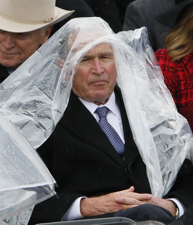 Former President George W. Bush keeps covered under the rain during the inauguration ceremonies swearing in Donald Trump as the 45th president of the United States on the West front of the U.S. Capitol in Washington, U.S., January 20, 2017. REUTERS/Rick Wilking