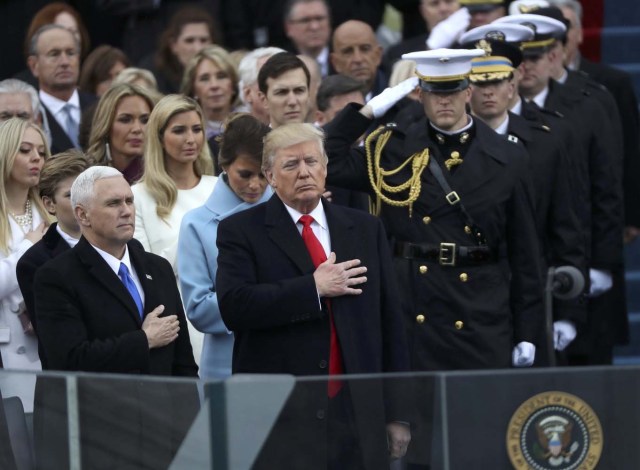 U.S. President Donald Trump and Vice President Mike Pence (L) stand for the singing of the U.S. National anthem during their inauguration ceremony at the U.S. Capitol in Washington, U.S., January 20, 2017. REUTERS/Carlos Barria