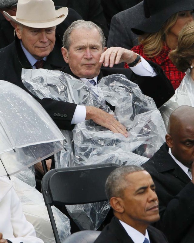 Former President George W. Bush takes off his cover under the rain during the inauguration ceremonies swearing in Donald Trump as the 45th president of the United States on the West front of the U.S. Capitol in Washington, U.S., January 20, 2017. REUTERS/Rick Wilking