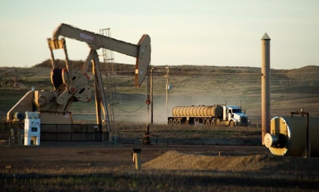 Imagen de archivo en la que se ve un camión cisterna pasando junto a un pozo de petróleo en la reserva india Fort Berthold en Dakota del Norte, el 1 de noviembre de 2014.La OPEP podría extender el pacto de reducción de bombeo que tiene con exportadores externos al grupo, o incluso aplicar recortes más profundos a partir de julio, si los inventarios globales de crudo no bajan al objetivo establecido, dijeron fuentes del cartel. REUTERS/Andrew Cullen