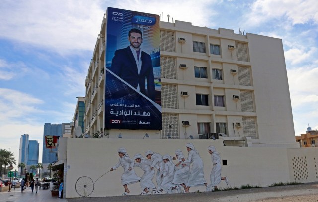 A picture taken on February 6, 2017 shows graffiti by Malaysian-based Lithuanian artist Ernest Zacharevic on a wall of Dubai's 2nd of December street, which is part of the government-funded Dubai Street Museum project. The streets of Dubai may be known for architectural superlatives like Burj Khalifa, the highest of the world's high-rises, and the Middle East's largest shopping centre Dubai Mall. But a group of street artists now also wants to turn the concrete walls of a fast-growing urban sprawl into an open-air museum that celebrates Emirati heritage and speaks to everyone in the multicultural city. / AFP PHOTO / NEZAR BALOUT