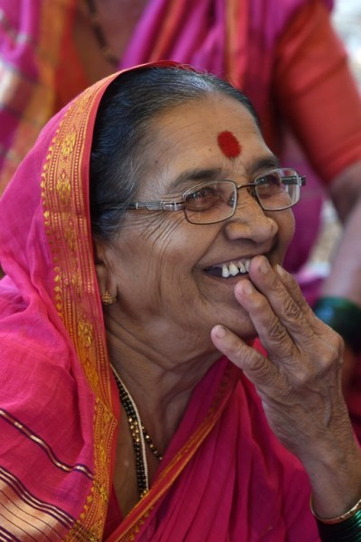 This photo taken on March 1, 2017 shows Indian grandmother Nirmala Kedar, 64, reading the Marathi alphabets in a class at Aajibaichi Shala, or "school for grannies" in the local Marathi language, in Phangane village in Maharashtra state's Thane district, some 125km northeast of Mumbai. They wear uniforms, carry satchels, and eagerly recite the alphabet in class, but the students here are different -- this is a "school for grannies". Deprived of an education as children, the women -- most of whom are widows and aged between 60 and 90 -- are finally fulfilling a life-long dream to become literate through this unique initiative near Mumbai. / AFP PHOTO / Indranil MUKHERJEE / TO GO WITH "India-education-women-school,FEATURE" by Peter HUTCHISON