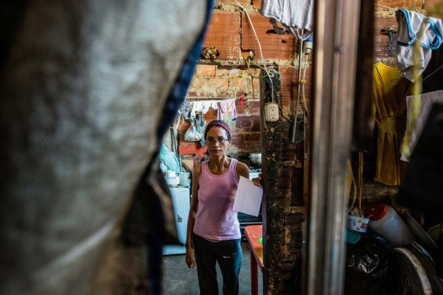 The mother of Venezuelan Rebeca Leon, who scavanges for food in the streets of Caracas, poses at their house in Petare shantytown, on February 22, 2017. Venezuelan President Nicolas Maduro is resisting opposition efforts to hold a vote on removing him from office. The opposition blames him for an economic crisis that has caused food shortages.  / AFP PHOTO / Federico PARRA