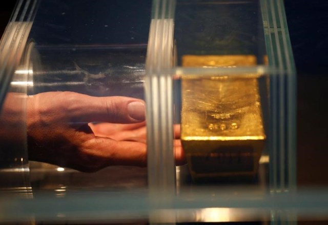 Un visitante toca una barra de oro de 12.5 kilos durante una visita en el Museo del dinero del Bundesbank alemán en Francfórt, Alemania.15 de diciembre 2016. El oro subía el lunes debido a que la incertidumbre creada por las elecciones en algunos países de Europa estimulaba el interés de los inversores por el metal, pero la perspectiva de una inminente alza de las tasas de interés en Estados Unidos mantenía los precios cerca de mínimos de cinco semanas alcanzados hace algunos días. REUTERS/Ralph Orlowski - RTX2VAHQ