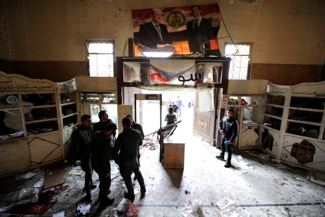 Security personnel stand near a damaged entrance after a suicide blast at the Palace of Justice in Damascus, Syria March 15, 2017. REUTERS/Omar Sanadiki