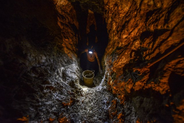 Ender Moreno looks for gold at La Culebra gold mine in El Callao, Bolivar state, southeastern Venezuela on March 1, 2017. Although life in the mines of eastern Venezuela is hard and dangerous, tens of thousands from all over the country head for the mines daily in overcrowded trucks, pushed by the rise in gold prices and by the severe economic crisis affecting the country, aggravated recently by the drop in oil prices. / AFP PHOTO / JUAN BARRETO