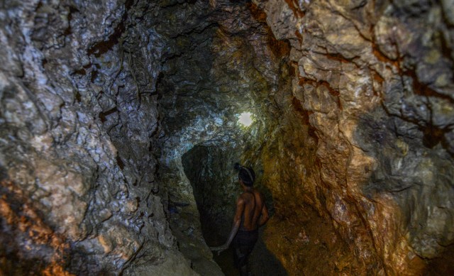 Ender Moreno looks for gold at La Culebra gold mine in El Callao, Bolivar state, southeastern Venezuela on March 1, 2017. Although life in the mines of eastern Venezuela is hard and dangerous, tens of thousands from all over the country head for the mines daily in overcrowded trucks, pushed by the rise in gold prices and by the severe economic crisis affecting the country, aggravated recently by the drop in oil prices. / AFP PHOTO / JUAN BARRETO / TO GO WITH AFP STORY by Maria Isabel SANCHEZ