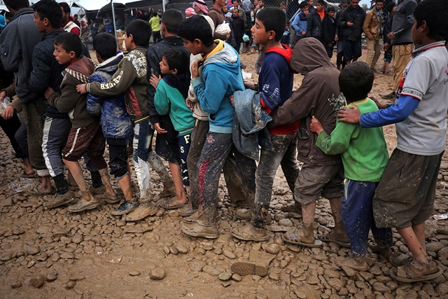 Niños hacen fila para recibir raciones en el campo de Hammam al-Alil, al sur de Mosul