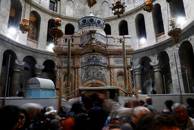 Visitantes cerca del recién restaurado edículo en la iglesia del Santo Sepulcro de Jerusalén, Israel, el 20 de marzo de 2017.