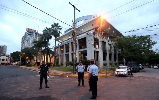 Unos policías realizando una guardia a las afueras del Congreso en Asunción, abr 5, 2017. Empresarios de Paraguay urgen al Congreso que abandone una propuesta que permitiría al presidente Horacio Cartes buscar su reelección, por temor a que el enojo popular ponga en riesgo los progresos para atraer inversión extranjera logrados por el Gobierno.      REUTERS/Marcos Brindicci