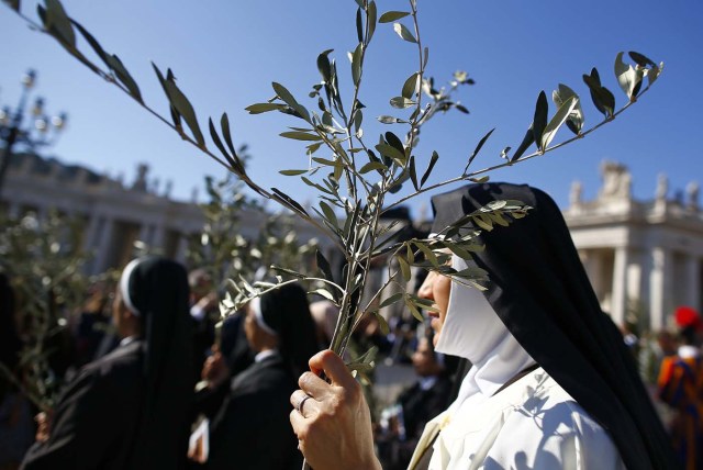 A nun holds a palm during the the Palm Sunday Mass led by Pope Francis in Saint Peter's Square at the Vatican April 9, 2017. REUTERS/Tony Gentile