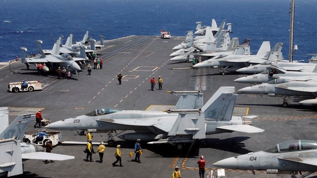 Personal de la Marina estadounidense preparándose para el despegue de un avión de combate F18 desde la cubierta del portaaviones USS Carl Vinson.