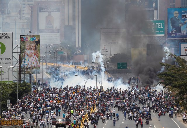 Policías antidisturbios y opositores al Gobierno de Nicolás Maduro enfrentados durante una manifestación en Caracas, abr 10, 2017. Miles de simpatizantes de la oposición venezolana volvieron el lunes a las calles del país petrolero para protestar contra el presidente Nicolás Maduro, al que acusan de haber desvirtuado su gobierno convirtiéndolo en una dictadura.  REUTERS/Christian Veron