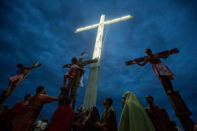 Un grupo de personas participan en la representación del viacrucis hoy, viernes 14 de abril de 2017, por las calles del barrio Petare en Caracas (Venezuela). EFE/MIGUEL GUTIÉRREZ