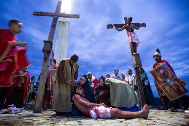 Un grupo de personas participan en la representación del viacrucis hoy, viernes 14 de abril de 2017, por las calles del barrio Petare en Caracas (Venezuela). EFE/MIGUEL GUTIÉRREZ