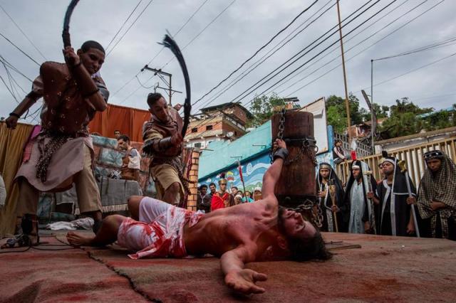 Un grupo de personas participa en la representación del viacrucis hoy, viernes 14 de abril de 2017, por las calles del barrio Petare en Caracas (Venezuela). EFE/MIGUEL GUTIÉRREZ