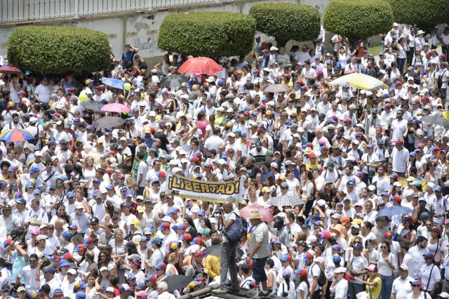 Opposition activists march towards the Catholic Church's episcopal seats nationwide, in Caracas, on April 22, 2017. Venezuelans gathered Saturday for "silent marches" against President Nicolas Maduro, a test of his government's tolerance for peaceful protests after three weeks of violent unrest that has left 20 people dead. / AFP PHOTO / FEDERICO PARRA