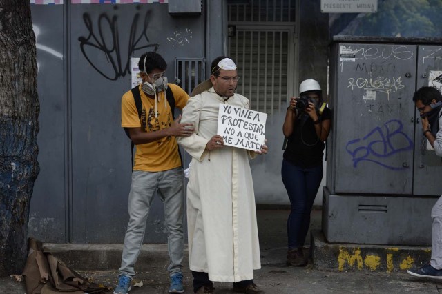 Opposition activists take part in a march against President Nicolas Maduro, in Caracas on May 1, 2017. Security forces in riot vans blocked off central Caracas Monday as Venezuela braced for pro- and anti-government May Day protests one month after a wave of deadly political unrest erupted.  / AFP PHOTO / FEDERICO PARRA