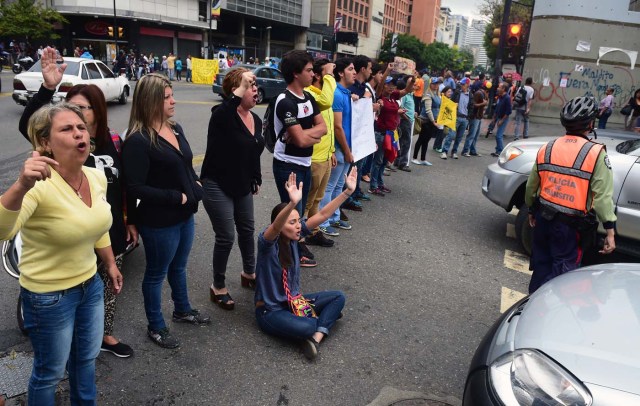 Demonstrators block a street during a protest against Venezuelan President Nicolas Maduro in Caracas, on May 2, 2017. Venezuelan President Nicolas Maduro called for a new constitution Monday as he fights to quell a crisis that has led to more than a month of protests against him and deadly street violence. The opposition slammed the tactic as a "coup d'etat" and urged protesters to "block the streets" from Tuesday. It said it was organizing a "mega protest" for Wednesday. / AFP PHOTO / RONALDO SCHEMIDT